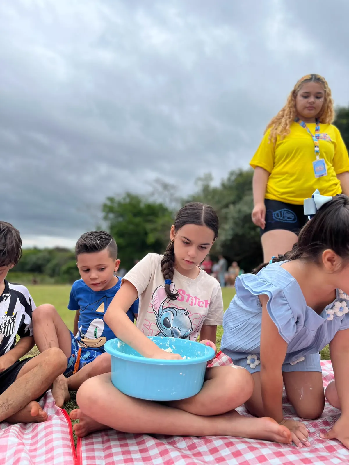 Recreadora brincando com as crianças em piquenique